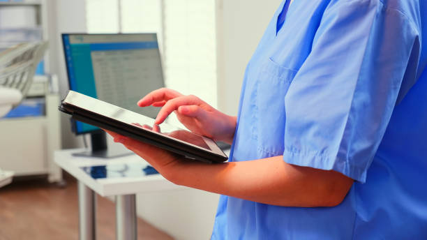 Close up of assistant holding tablet and analysing teeth x-ray