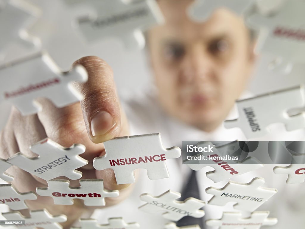 Insurance Businessman putting jigsaw puzzle pieces. Insurance Agent Stock Photo