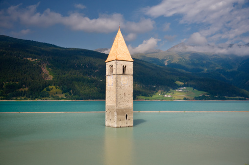 The old church tower of Graun rising from the waters of Lago Di Resia (Reschensee).