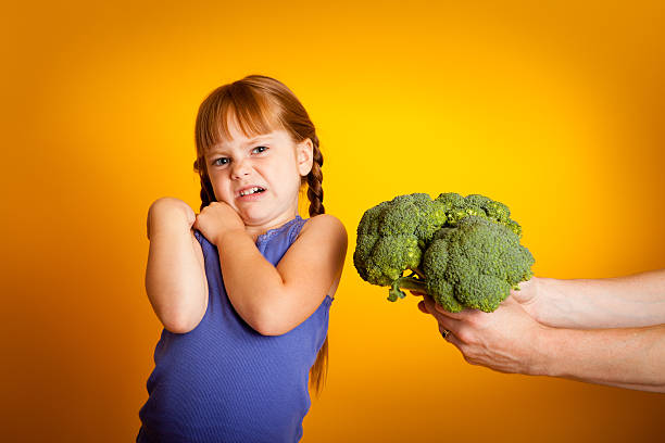 istock Color Image of Young Girl Making a Face at Broccoli 186830654