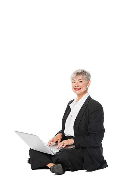 sênior mulher de negócios com laptop sentado no chão - idoso na internet - fotografias e filmes do acervo