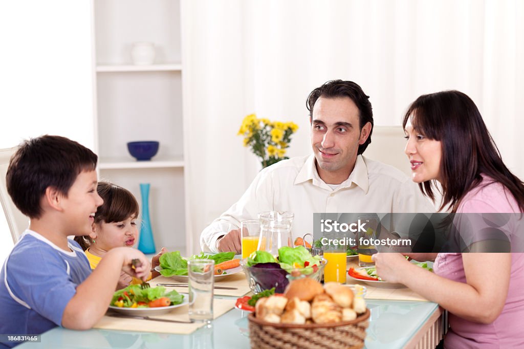 Feliz familia comiendo verduras para la cena juntos - Foto de stock de Adulto libre de derechos