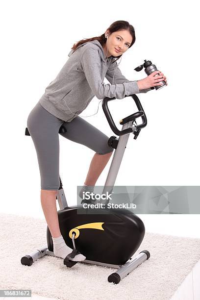 Mujer Joven En Bicicleta Fija Foto de stock y más banco de imágenes de Bicicleta estática - Bicicleta estática, Recortable, 16-17 años