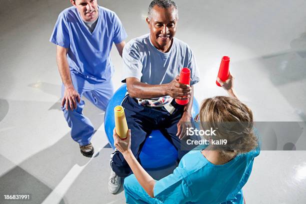 Alter Mann Mit Körperlichen Therapeuten Mit Gymnastikball Und Klimaanlage Stockfoto und mehr Bilder von Ergotherapie