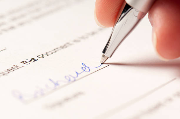istock Hand holding ballpoint pen signing signature 186832052