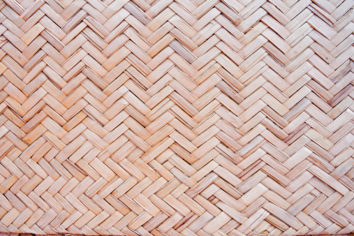Close-up of weaving texture of a beach mat made from woven palm fronds.