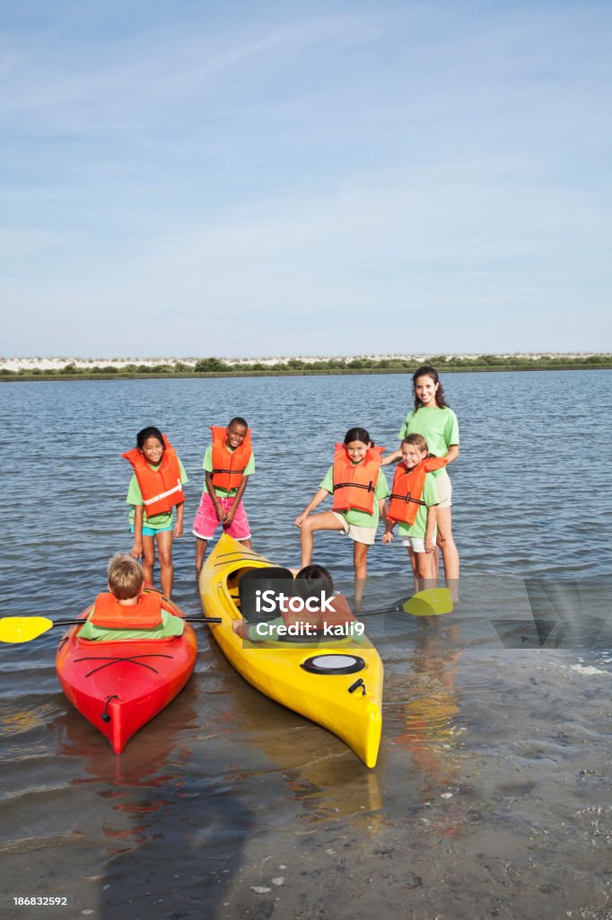 Ajudante de Colônia de Férias de verão e crianças com caiaques - Foto de stock de 12-13 Anos royalty-free