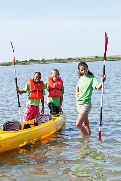 adolescente com meninos pronto para um passeio de caiaque - summer camp child teenager kayak - fotografias e filmes do acervo