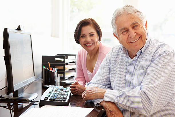 hispânico casal sênior trabalhando com computador em casa - bill looking cheerful latin american and hispanic ethnicity - fotografias e filmes do acervo