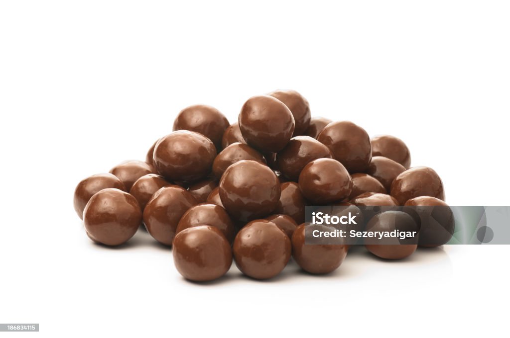 Dipped chocolate peanuts in a pile on a white background "Dipped Chocolate peanuts, Isolated" Chocolate Dipped Stock Photo