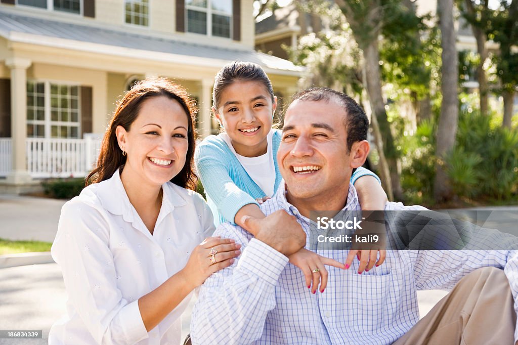 Portrait heureux hispanique famille assis avec maison en arrière-plan - Photo de Famille libre de droits