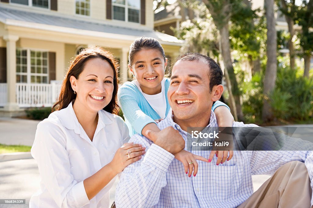 Портрет Счастливая Латиноамериканская семья, сидящая с Дом на заднем плане - Стоковые фото Семья роялти-фри