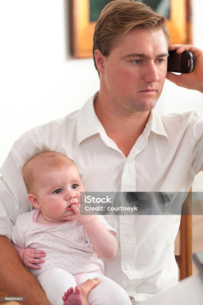 Ojciec gospodarstwa dziecka podczas rozmów telefonicznych - Zbiór zdjęć royalty-free (Ojciec)