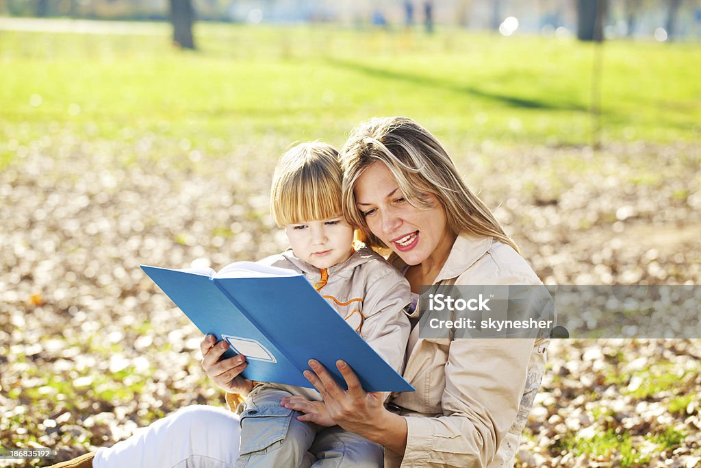 Mutter und Sohn Lesen eines Buches im Freien. - Lizenzfrei Alleinerzieherin Stock-Foto