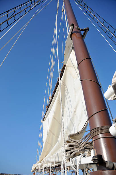 Gaff Rig Sails Sail going up mast of schooner ship. gaff sails stock pictures, royalty-free photos & images