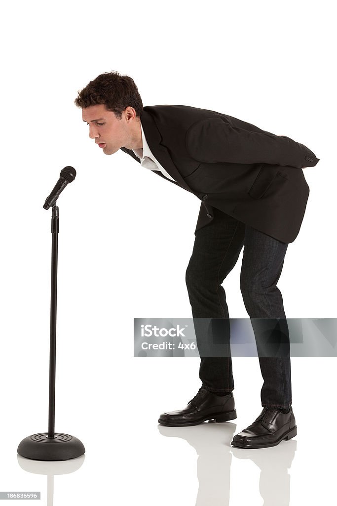 Hombre de negocios hablando en micrófono - Foto de stock de Base de pie para micrófono libre de derechos