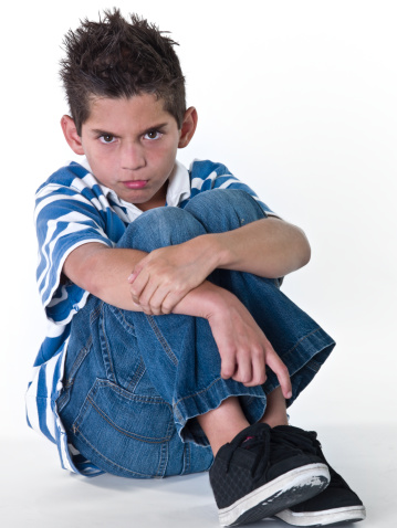 Hispanic little boy sitting on the floor very upset on white background (this picture has been taken with a super high definition Hasselblad H3D II 31 megapixels camera)
