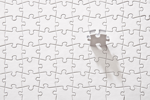 A blank puzzle with a missing piece on a white surface