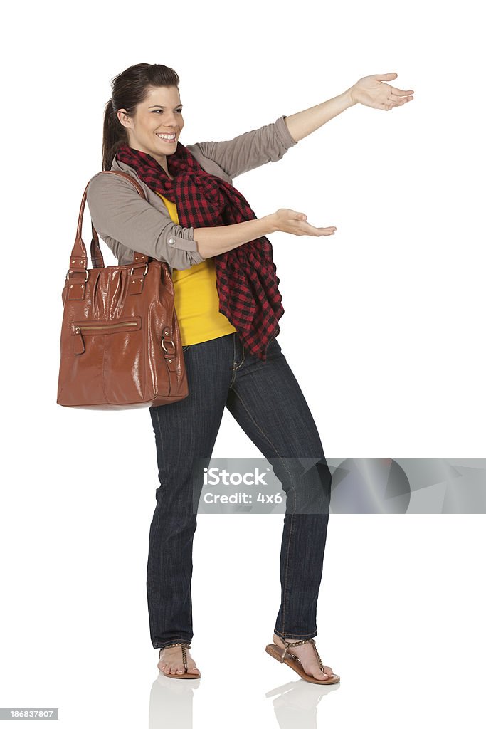 Mujer feliz con una bolsa de transporte de cuero y Gesticular - Foto de stock de 20 a 29 años libre de derechos