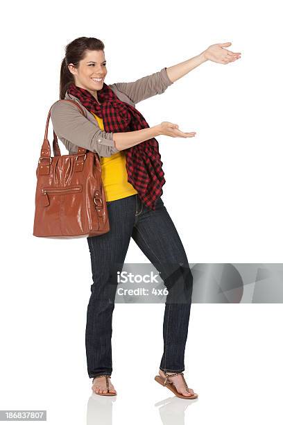 Mujer Feliz Con Una Bolsa De Transporte De Cuero Y Gesticular Foto de stock y más banco de imágenes de 20 a 29 años