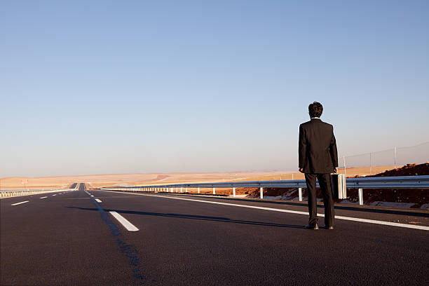 istock Lost Lonely Businessman Walking In Empty The Highway 186838216