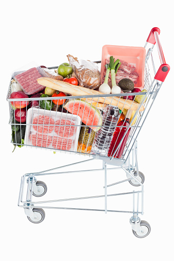 Shopping cart full of food on white background