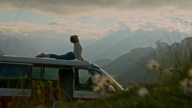SLO MO Woman Practicing Yoga on Top of Van in Remote Mountains