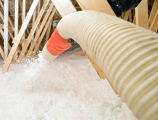 trabajador de pulverización aislamiento de fibra de vidrio soplado entre ático trusses - insulation roof attic home improvement fotografías e imágenes de stock