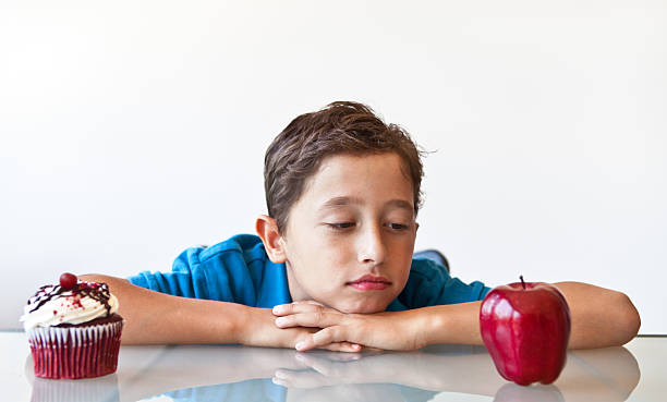 istock Boy trying to make a healthy food choice 186839131