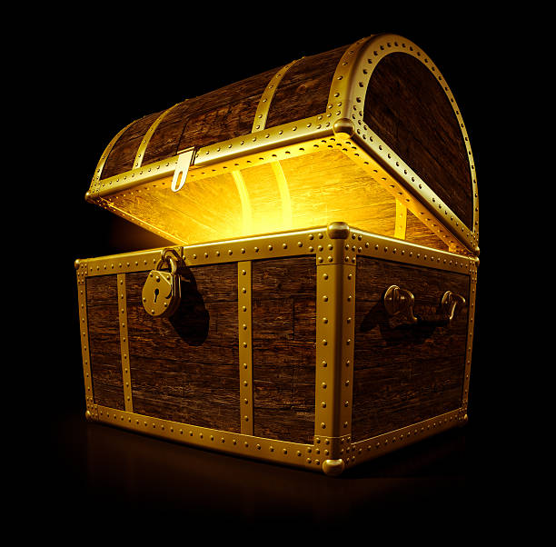 A treasure chest with a glowing light Three quarter view of a open treasure chest with a golden glow emanating from inside isolated on a black background. treasure chest photos stock pictures, royalty-free photos & images