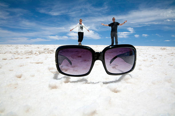 sonnenbrille illusion spaß: salt flats, bolivien - illusion giant women small stock-fotos und bilder