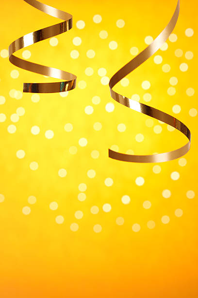 golden et cotillons sur fond flou léger - ribbon curled up hanging christmas photos et images de collection
