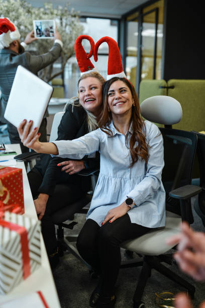 istock Fun Times For Female Colleagues Taking Selfie During Christmas Celebration 1868409491