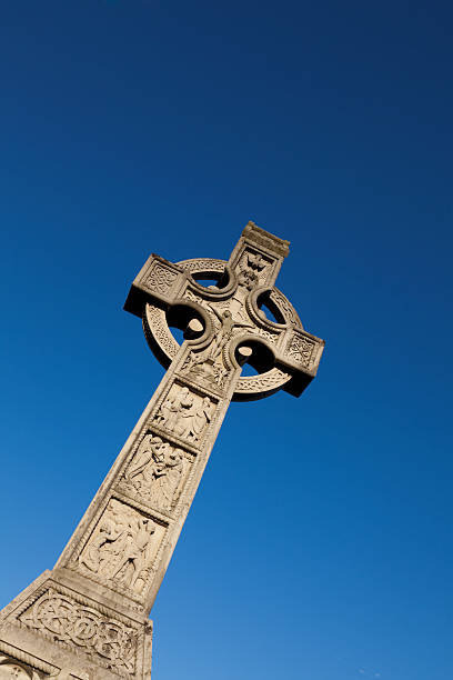 большой кельтский крест с голубой небесный фон - celtic cross cross shape blue vertical стоковые фото и изображения