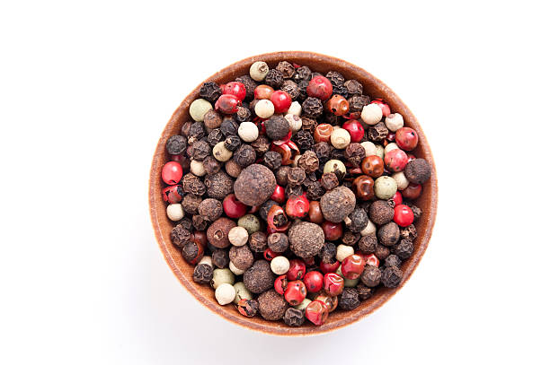 a mixture of peppers is scattered from a jar on a white background. traditional spices for cooking.