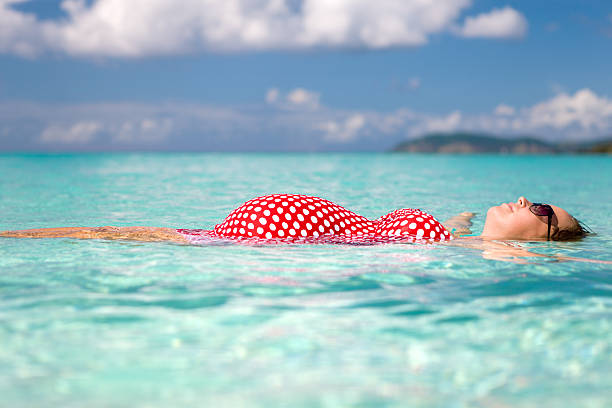 femme enceinte flotter sur l'eau à la plage dans les caraïbes - swimwear caribbean sea beach water photos et images de collection