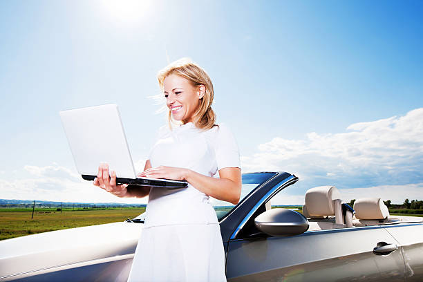 istock Young woman using her laptop against the sky and clouds. 186842968
