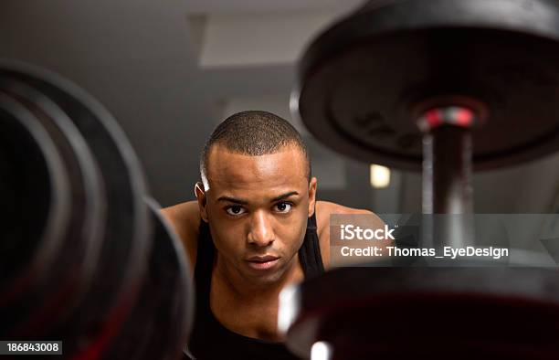 Young Man Looking At Dumbbells Stock Photo - Download Image Now - 20-24 Years, 20-29 Years, Active Lifestyle