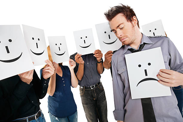 istock Young Man Holding Sad Face Among Happy People With Signs 186843408