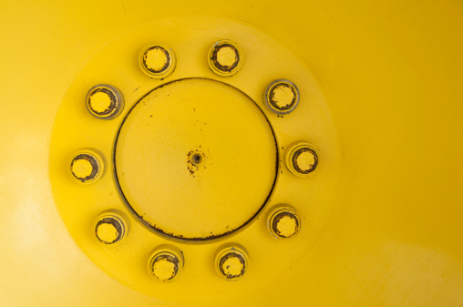A close-up of the hub of a tractor provides a colorful and circular backdrop.  Converted from RAW file with 16 bit processing.