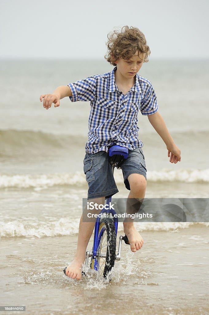 Ragazzo equitazione Monociclo in mare - Foto stock royalty-free di 8-9 anni