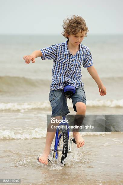 Ragazzo Equitazione Monociclo In Mare - Fotografie stock e altre immagini di 8-9 anni - 8-9 anni, Bambini maschi, Bambino