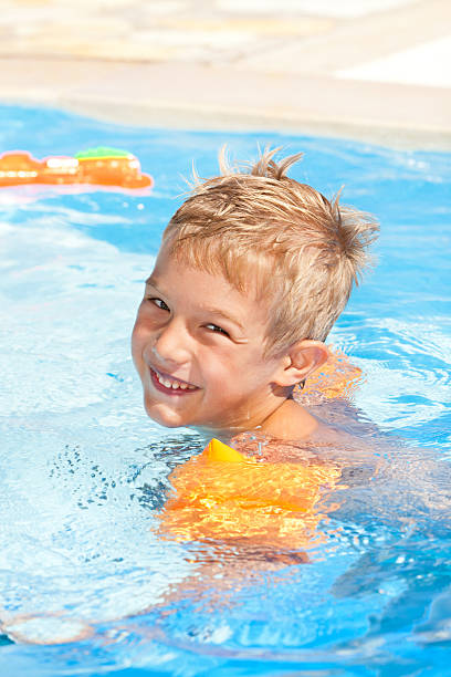 istock Child with water wings relaxing the swimming pool 186845050