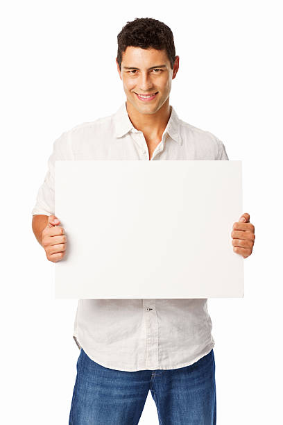 Handsome young man holds a blank sign in his hands with room for adding text. Vertical shot. Isolated on white.