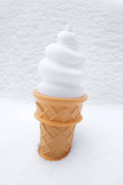 Female hand in knitted gloves with ice cream in a waffle horn on the winter snowfall background. Concept