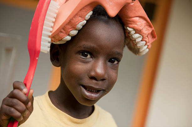African boy with dentures and toothbrush