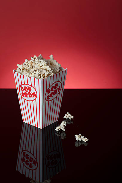 istock Box of popcorn on reflective surface and red background 186845841