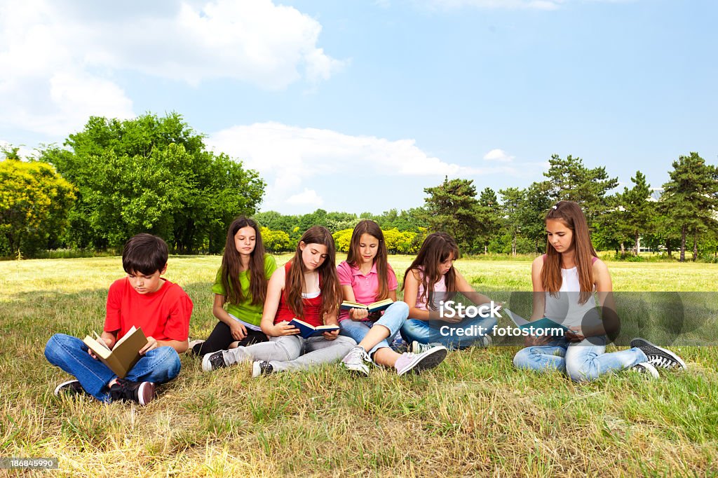 Grupo de niños leyendo libros al aire libre - Foto de stock de Campo - Tierra cultivada libre de derechos