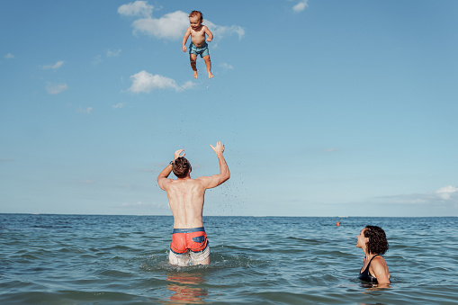 Father with two sons on the beach.