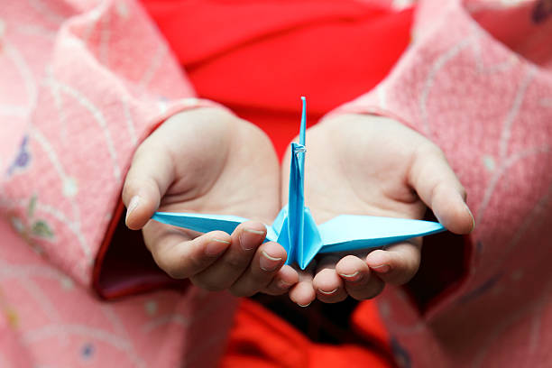 Girl hands holding an origami crane stock photo